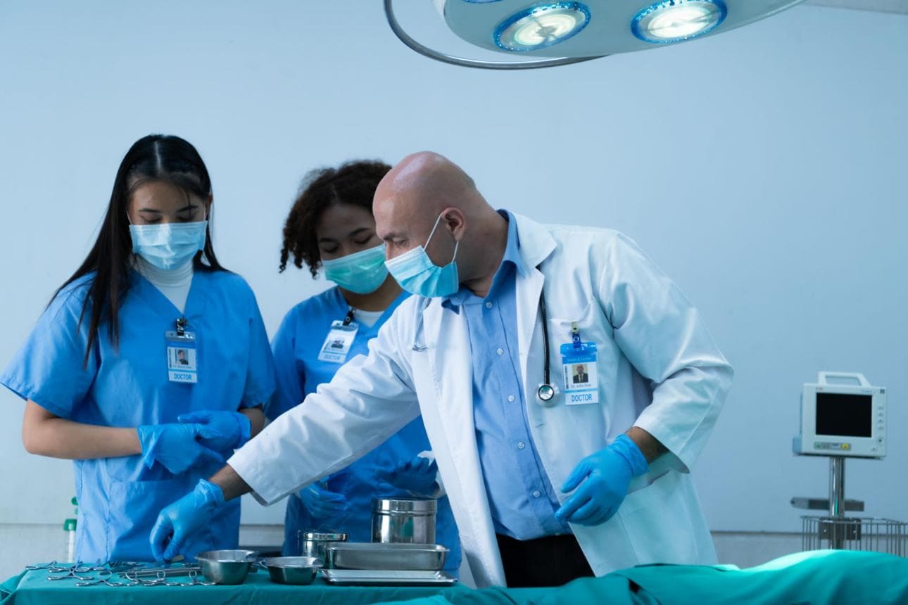 Clinical mentor supervising a trainee during hair restoration procedure preparation